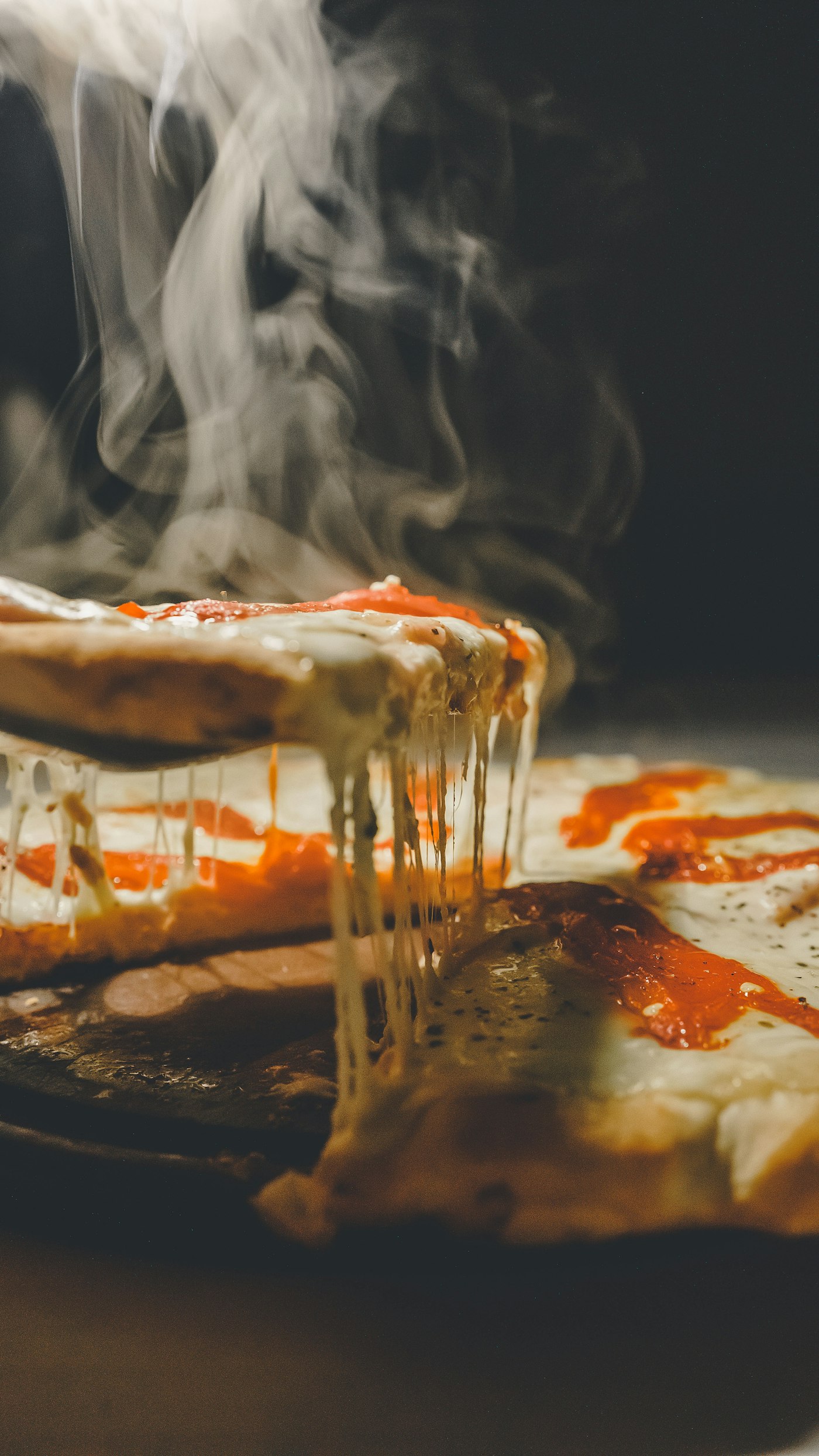 Pizza artesanal com queijo derretendo, saindo do forno a lenha