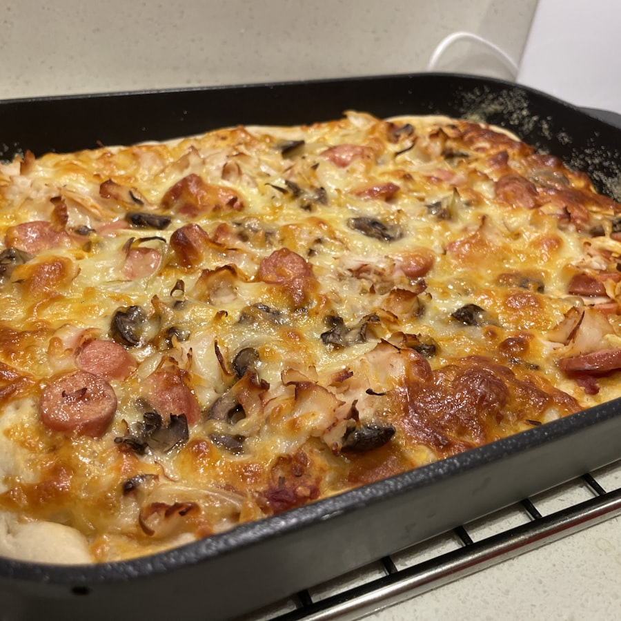 Pizza com bacon, calabresa e cogumelos em fôrma